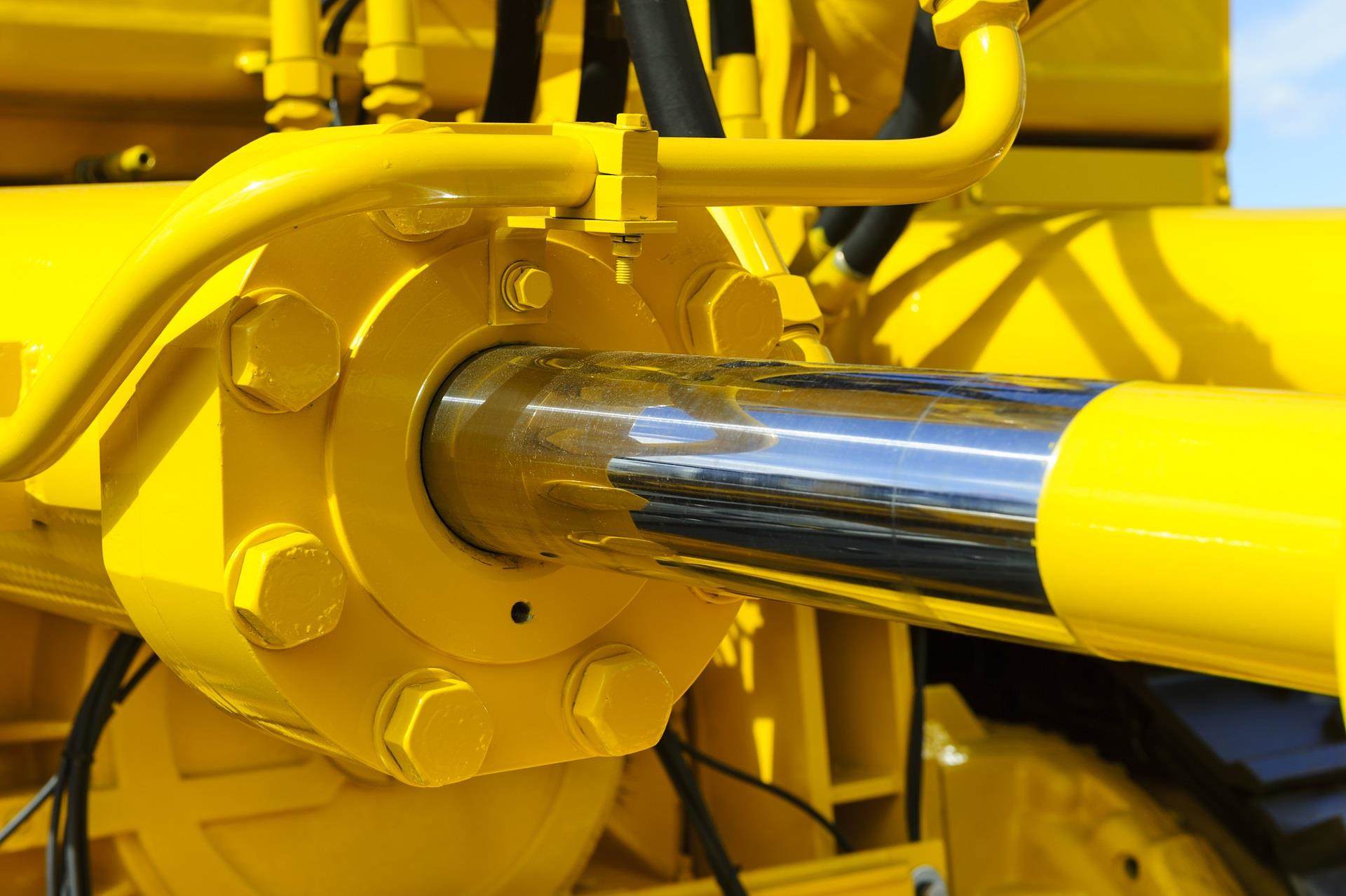 Yellow hydraulic cylinder on heavy machinery.